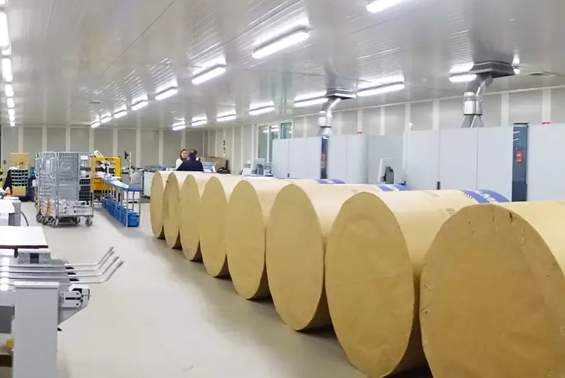 Grote papierrollen staan opgesteld in de drukkerij als voorbereiding op de productie van gepersonaliseerde printcommunicatie.